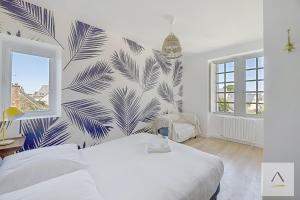 a bedroom with a white bed and a blue and white wall at La Villa Moorings in Saint Malo