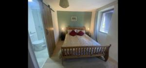 a bedroom with a bed with two red pillows at Les Pipistrelles de Planechaud in Saint-Sornin-Leulac