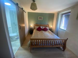 a bedroom with a bed with two red pillows at Les Pipistrelles de Planechaud in Saint-Sornin-Leulac +5 photos