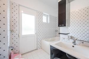 a bathroom with a tub and a sink and a window at Hometown Apartment by PikHost in Gjirokastër +37 photos
