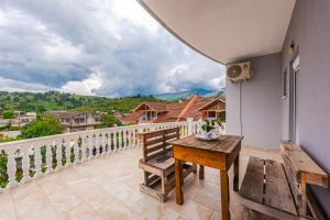 a balcony with a wooden bench and a table at Hometown Apartment by PikHost in Gjirokastër