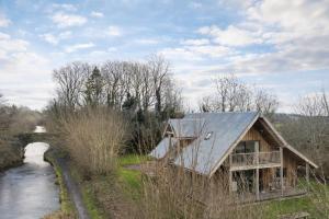 a house with a metal roof next to a river at Finest Retreats - Canal Central in Ball