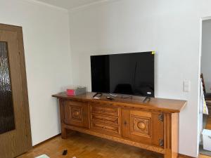 a flat screen tv sitting on top of a wooden dresser at Ferienhaus Südpfälzer Wald in Spirkelbach
