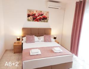 a bedroom with a bed with a painting on the wall at Apartmani Dalibor, Stanići - Omiš in Stanići