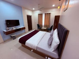 a hotel room with a bed and a tv at Hotel Silver Leaf - Vile Parle East - Near Mumbai Airport in Mumbai