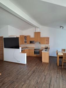 a large kitchen with wooden cabinets and a table at Haus Nadegger in Werfen