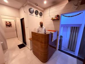 a man standing behind a bar in a room at Hotel Silver Leaf - Vile Parle East - Near Mumbai Airport in Mumbai