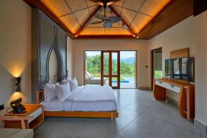 a bedroom with a bed with a ceiling fan and a television at Hotel Sonar Bangla Ajodhya Hills in Purulia