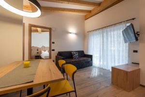 a living room with a table and a couch at Vacanze la Malga in Predazzo