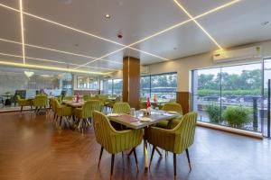a dining room with tables and chairs and windows at Arch The Venus - Free Airport Pickup or Drop in New Delhi