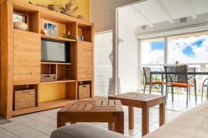 a living room with a television and a table and chairs at Appartement Coconut in Saint-François