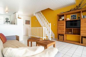 a living room with a couch and a tv at Appartement Coconut in Saint-François