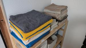 a bunch of towels are stacked on a shelf at 民泊 Knock Knock in Habikino