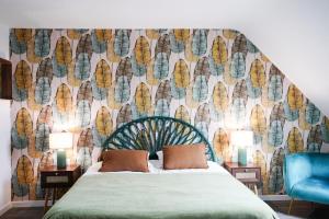 a bedroom with a bed and a wall mural at Jungle Room - Studio avec spa privé in Quéven