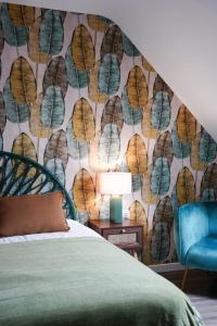 a bedroom with a wall mural of leaves at Jungle Room - Studio avec spa privé in Quéven