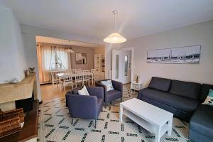 a living room with a couch and a table at Large family house 300m from the beach in Arcachon