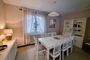 a dining room with a white table and chairs at Large family house 300m from the beach in Arcachon