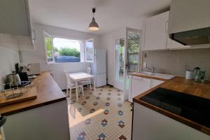 a kitchen with a counter and a table in it at Large family house 300m from the beach in Arcachon