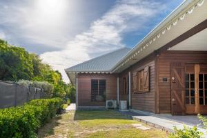 a house with a wooden door and a fence at Bungalow Kaz Mendé in Sainte-Anne