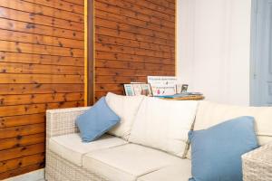 a living room with a white couch with blue pillows at Bungalow Kaz Mendé in Sainte-Anne +11 photos