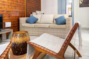 a living room with a wicker chair and a couch at Bungalow Kaz Mendé in Sainte-Anne
