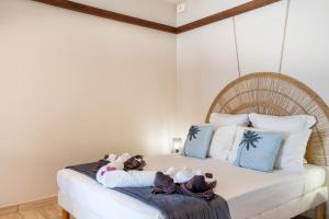 a bedroom with a bed with two stuffed animals on it at Bungalow Kaz Orchidée Oncidium in Sainte-Anne