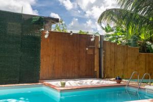 a swimming pool with a wooden fence next to a fence at Villa Kaz a Ramon in Port-Louis