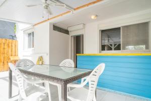 a dining room with a glass table and white chairs at Villa Kaz a Ramon in Port-Louis