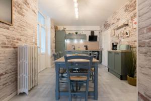 a kitchen with a blue table and chairs at The workshop in Metz