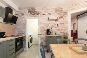 a kitchen with a brick wall and a table at The workshop in Metz