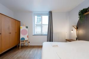 a bedroom with a bed and a large window at The workshop in Metz