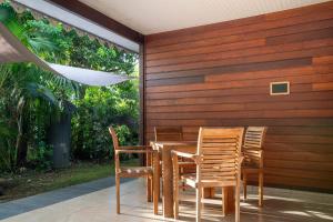 a wooden table and chairs on a patio at Bungalow Kaz Graj in Sainte-Anne +19 photos