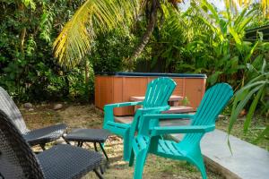two blue chairs sitting next to a table and chairs at Bungalow Kaz Graj in Sainte-Anne