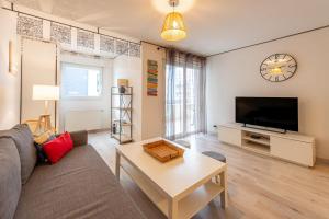 a living room with a couch and a tv and a table at 2 Rue du Parc in Annecy