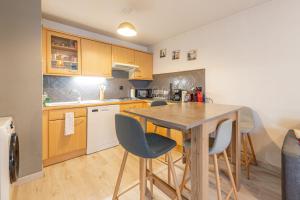 a kitchen with a wooden table and chairs at 2 Rue du Parc in Annecy