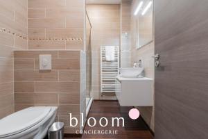 a bathroom with a white toilet and a sink at Le Fabuleux de Deroulede in Nancy