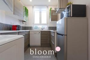 a white kitchen with a refrigerator and a sink at Le Fabuleux de Deroulede in Nancy
