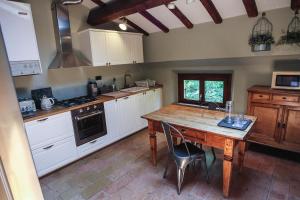 a kitchen with a wooden table and a kitchen with white cabinets at Guest House Dell'Affresco in Reggio Emilia