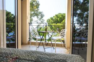1 dormitorio con balcón con mesa y sillas en De Lux Apartments, en Petrovac na Moru