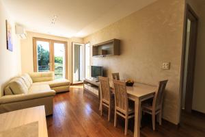 una sala de estar con una mesa y un sofá en De Lux Apartments, en Petrovac na Moru