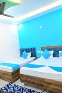 two beds in a room with blue lighting at Pushpanjli grand inn in Ayodhya