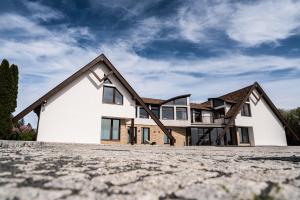a house with a large driveway in front of it at Lešná Penzion in Zlín