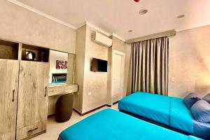 a bedroom with two blue beds and a tv at Heritage Cairo Hotel Taalat Harb in Cairo