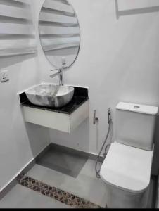 a bathroom with a sink and a toilet and a mirror at Mya Apartment in Madina