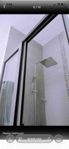 a glass window of a shower in a bathroom at Mya Apartment in Madina