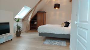 a bedroom with a bed and a flat screen tv at La Charmeraie d'Aumâtre in Aumâtre