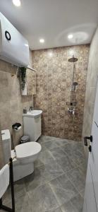 a bathroom with a toilet and a shower at By The Pool Apartments #10 in Velingrad