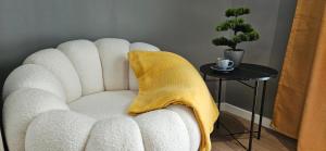 a white chair with a yellow blanket on a table at By The Pool Apartments #10 in Velingrad