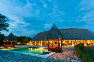 波波约Punta Teonoste Beach Resort的晚上有游泳池的度假村