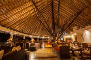 a large lobby with chairs and tables and a large ceiling at Hotel Punta Teonoste in Popoyo